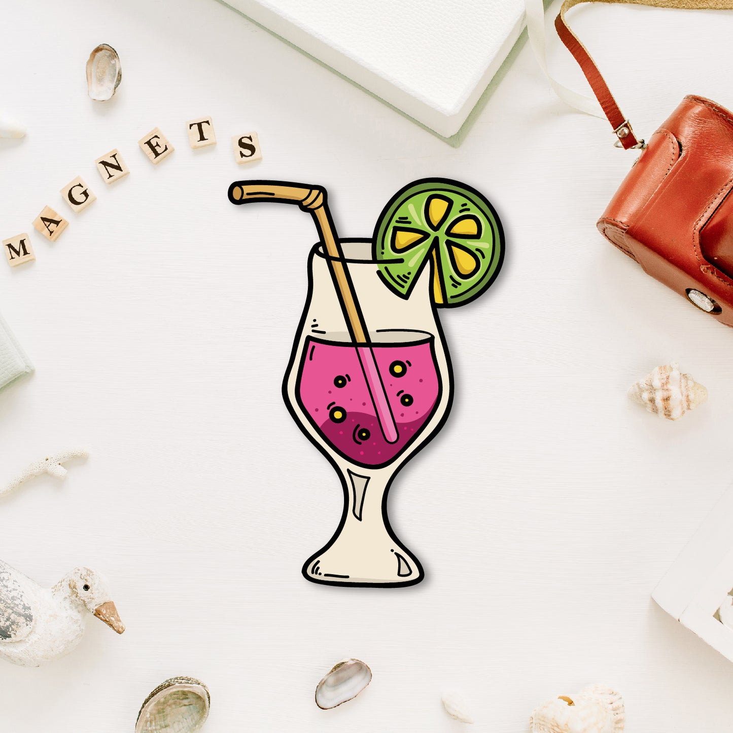 A vibrant, miniature cocktail glass-shaped fridge magnet with a straw and garnish.