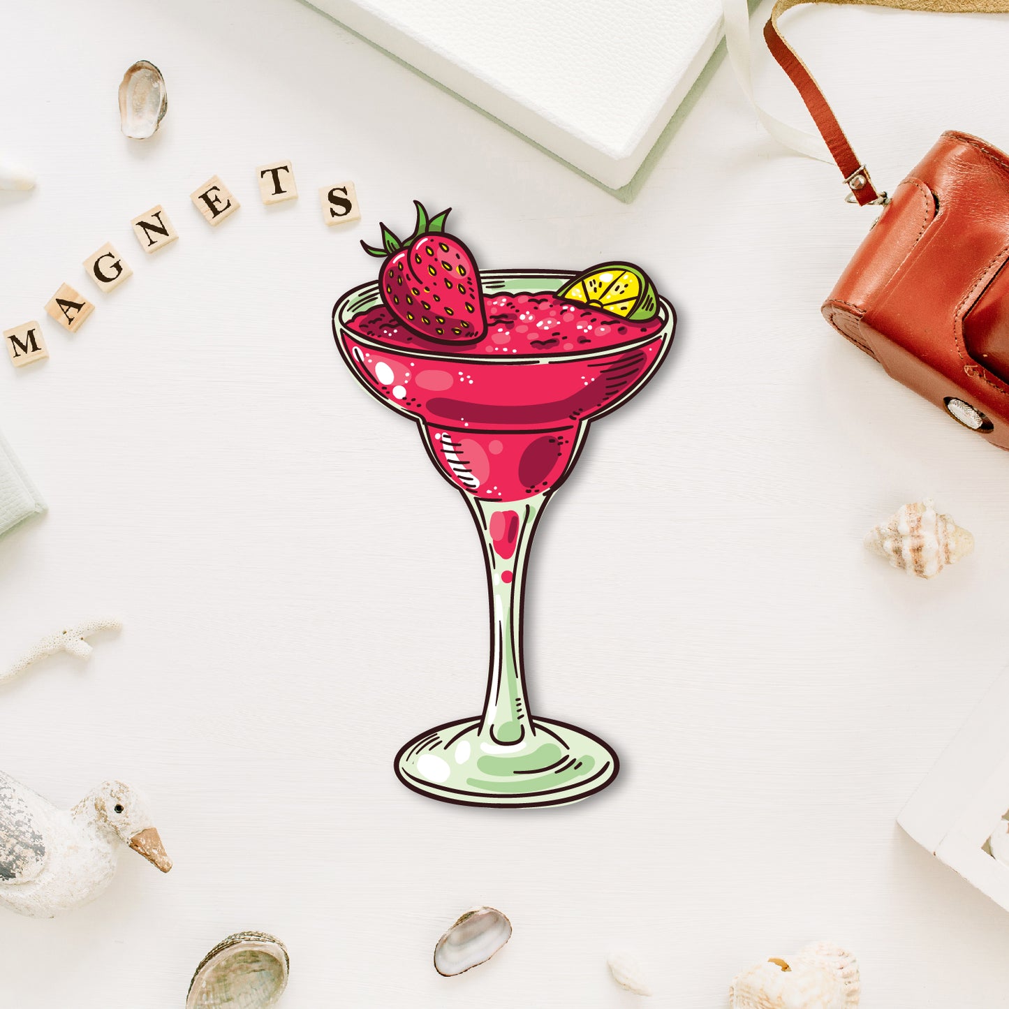 A miniature, elegant martini glass-shaped fridge magnet with an olive.
