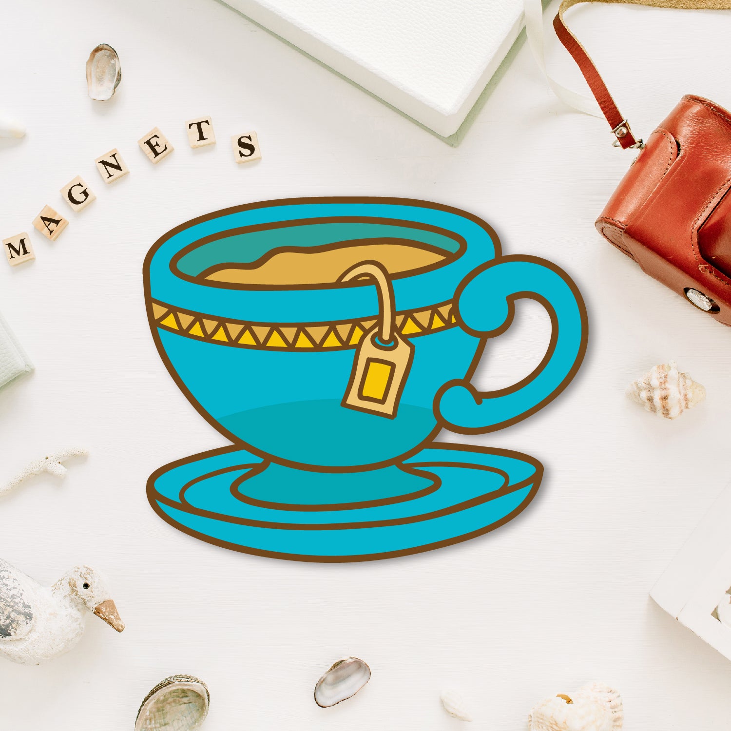 A miniature, charming tea cup-shaped fridge magnet with a saucer.