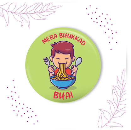Close-up detail of 'Bhukkad Bhai' inscription or food motif on metal Rakhi and magnet.