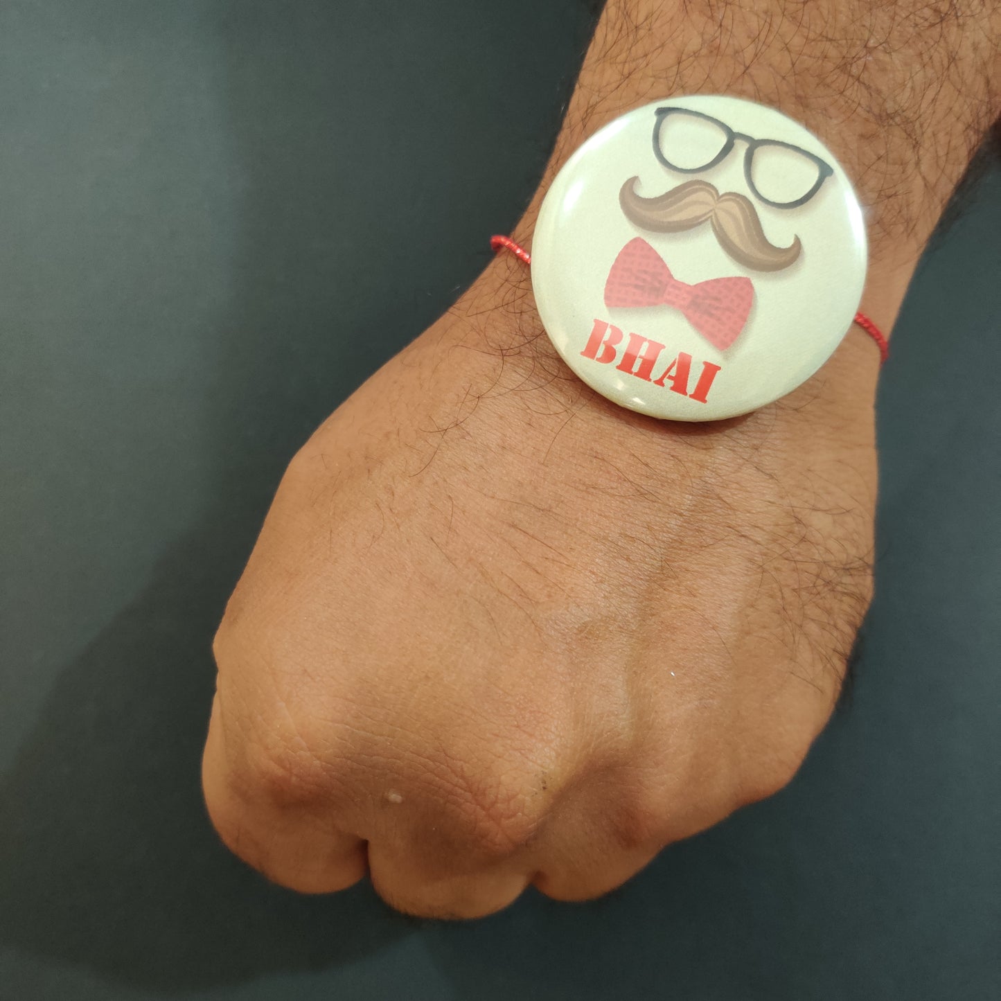 Moustache Bhai Rakhi shown both on a thread and as a fridge magnet.