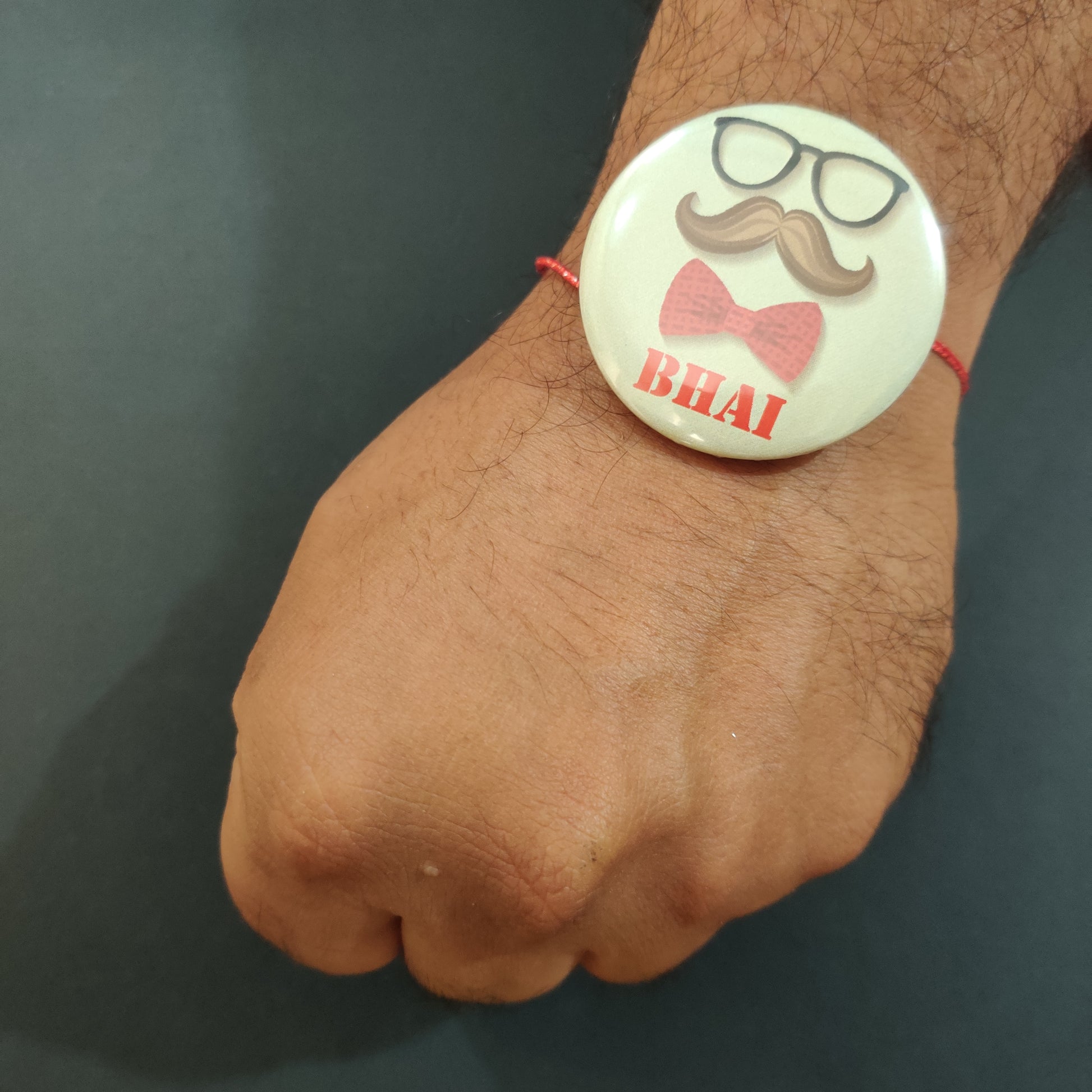 Moustache Bhai Rakhi shown both on a thread and as a fridge magnet.