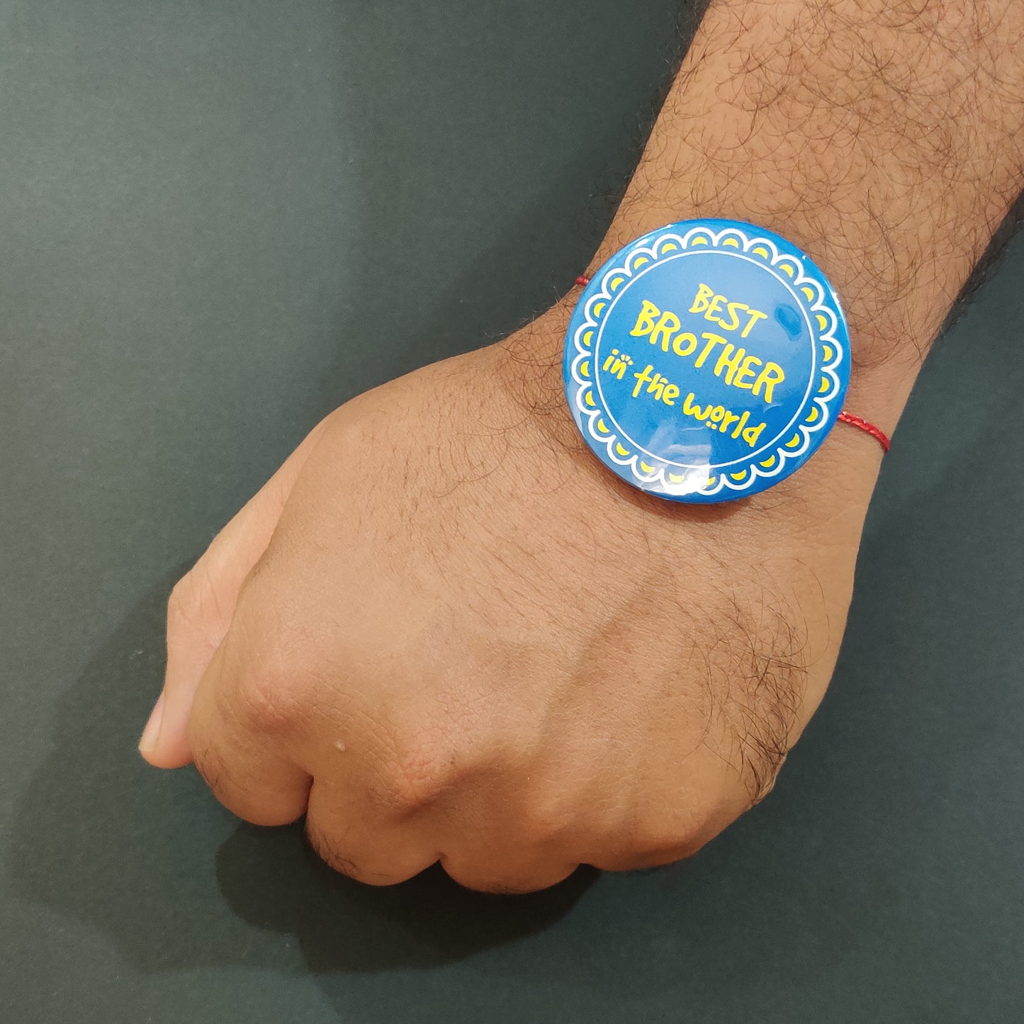 Best Brother in the World Rakhi shown both on a thread and as a fridge magnet.