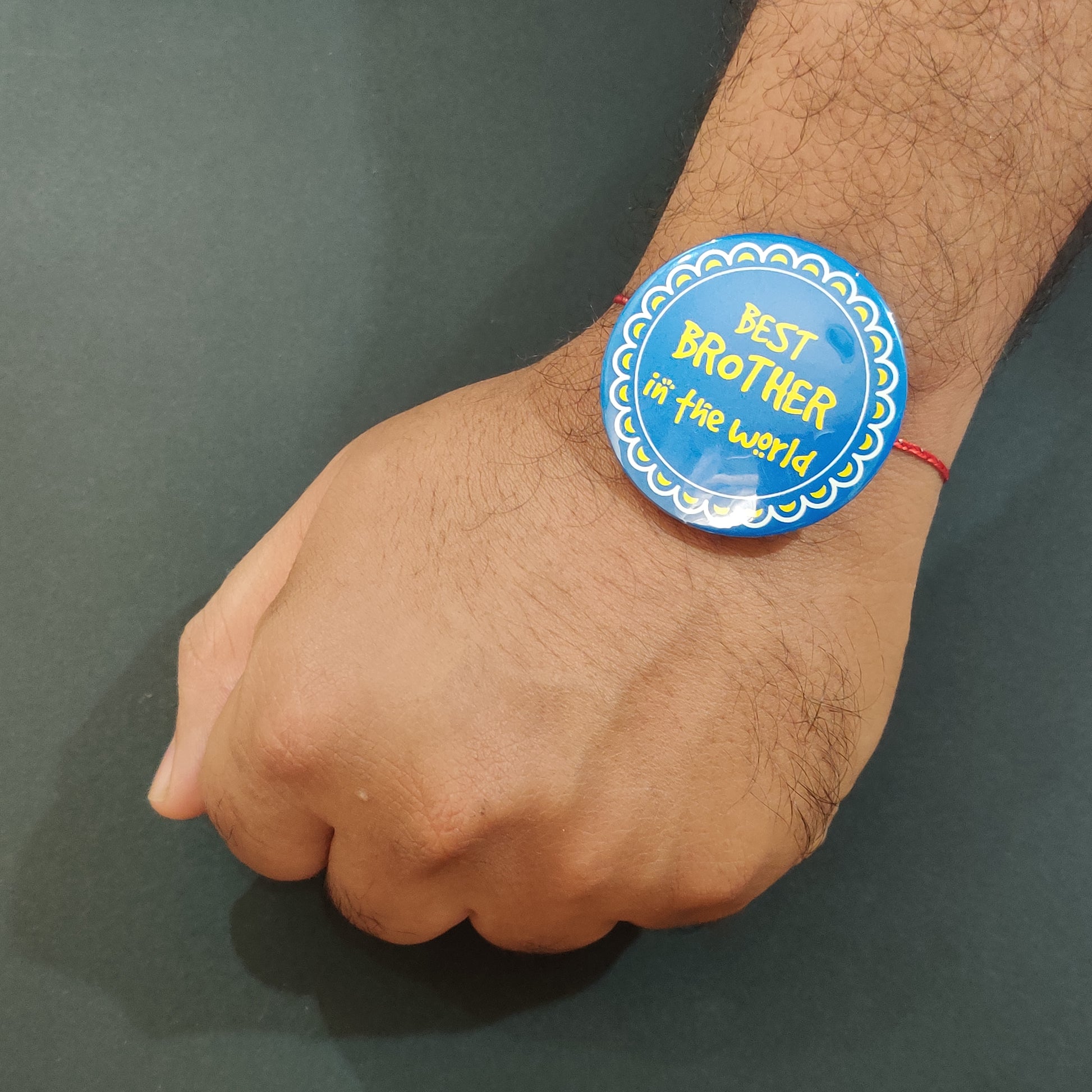 Best Brother in the World Rakhi shown both on a thread and as a fridge magnet.