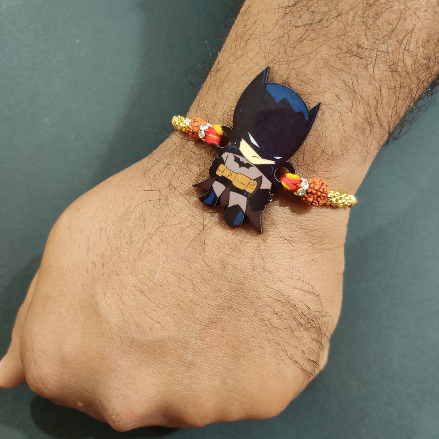 Vigilant Batman Wooden Rakhi with Rudraksha thread worn on a brother's wrist.