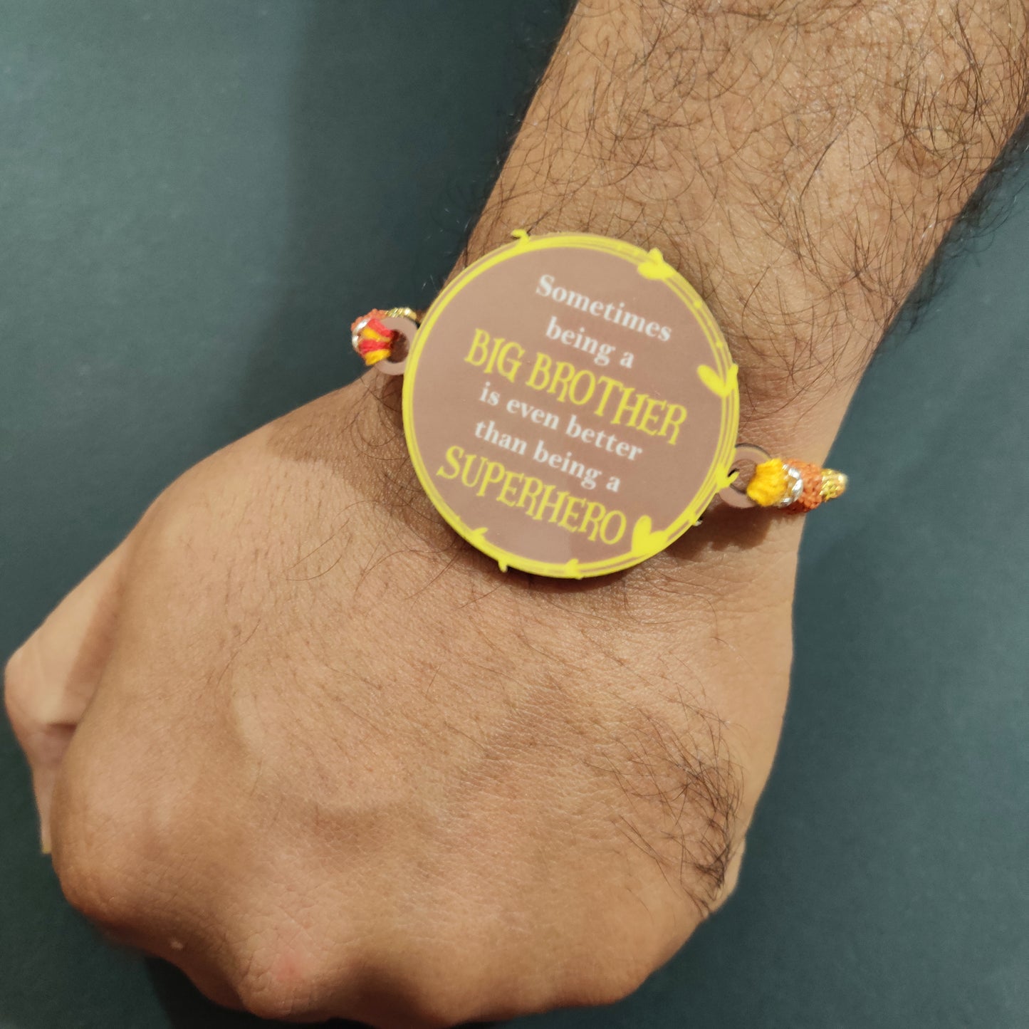 Unique Superhero Big Brother Wooden Rakhi with Rudraksha thread worn on an elder brother's wrist