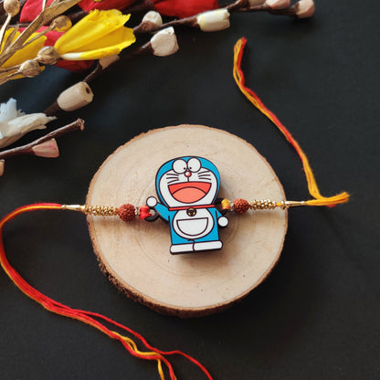 Doraemon Wooden Rakhi with Rudraksha thread, presented with Roli and Chawal for Raksha Bandhan.