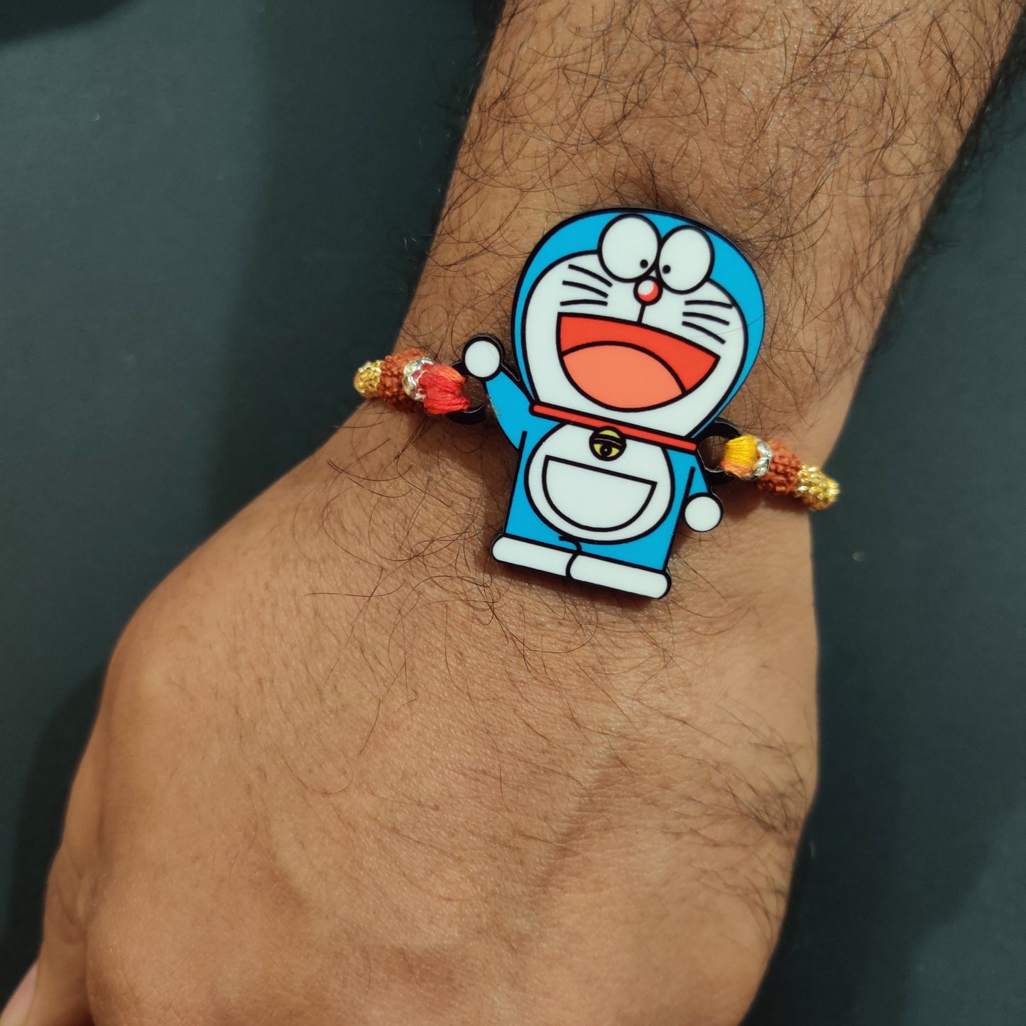 Charming Doraemon Wooden Rakhi with Rudraksha thread worn on a brother's wrist.