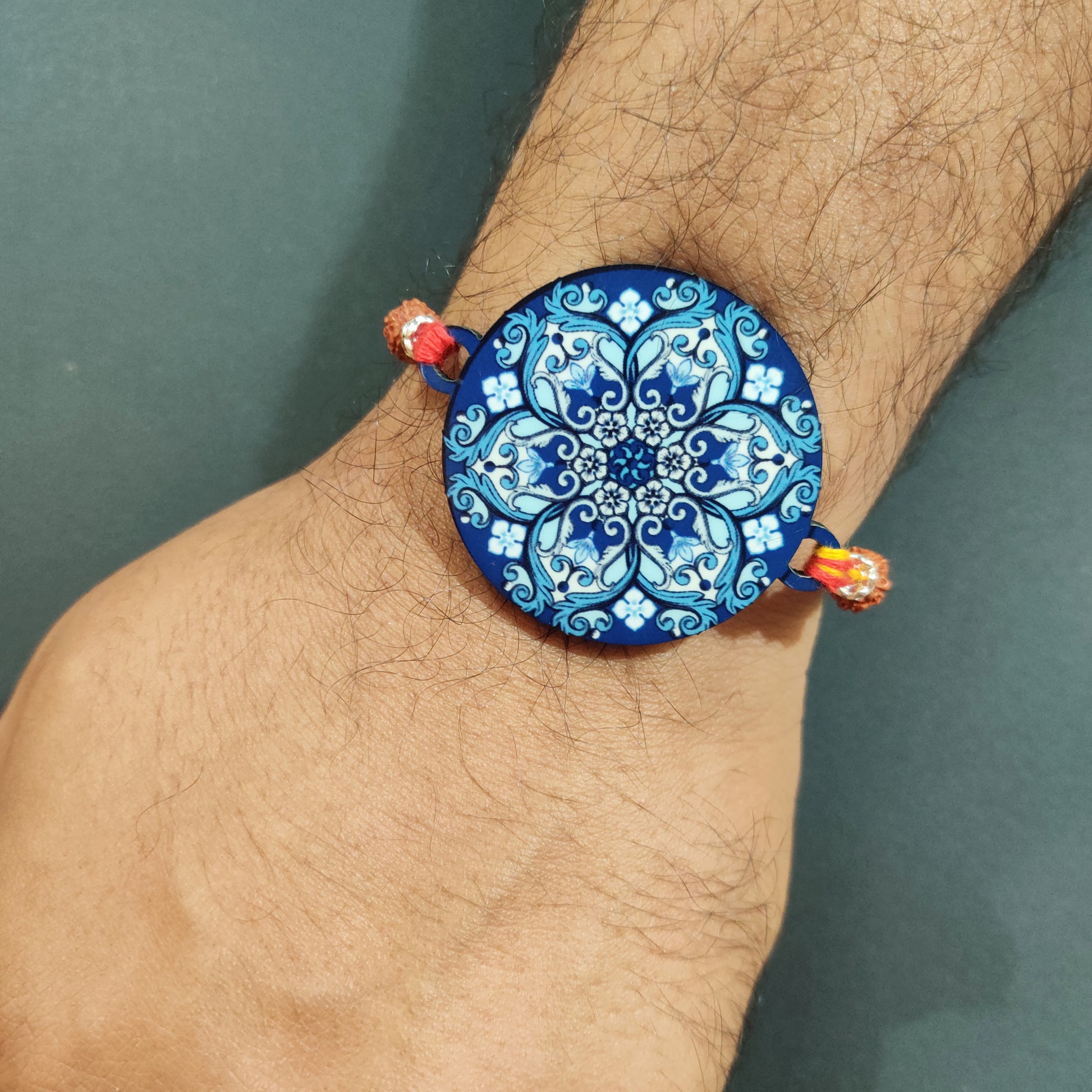 Ethnic Mandala Wooden Rakhi with Rudraksha thread tied on a brother's wrist