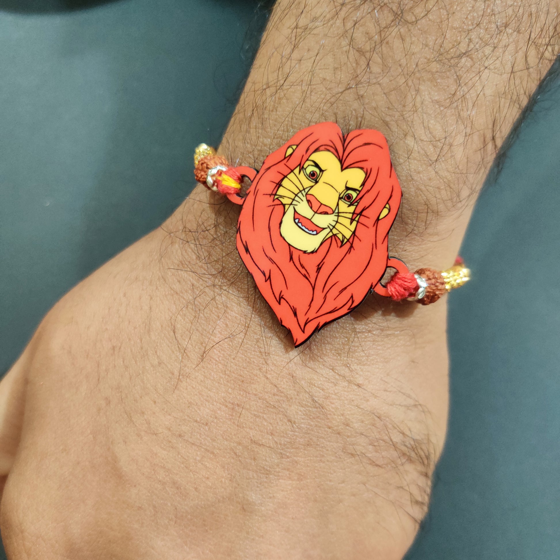 Regal Mufasa Wooden Rakhi with Rudraksha thread worn on a brother's wrist.