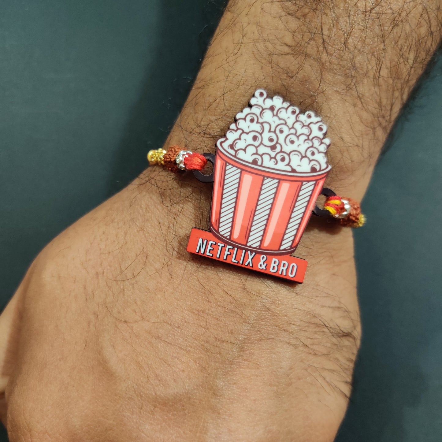 Cool Netflix & Bro Wooden Rakhi with Rudraksha thread worn on a brother's wrist.