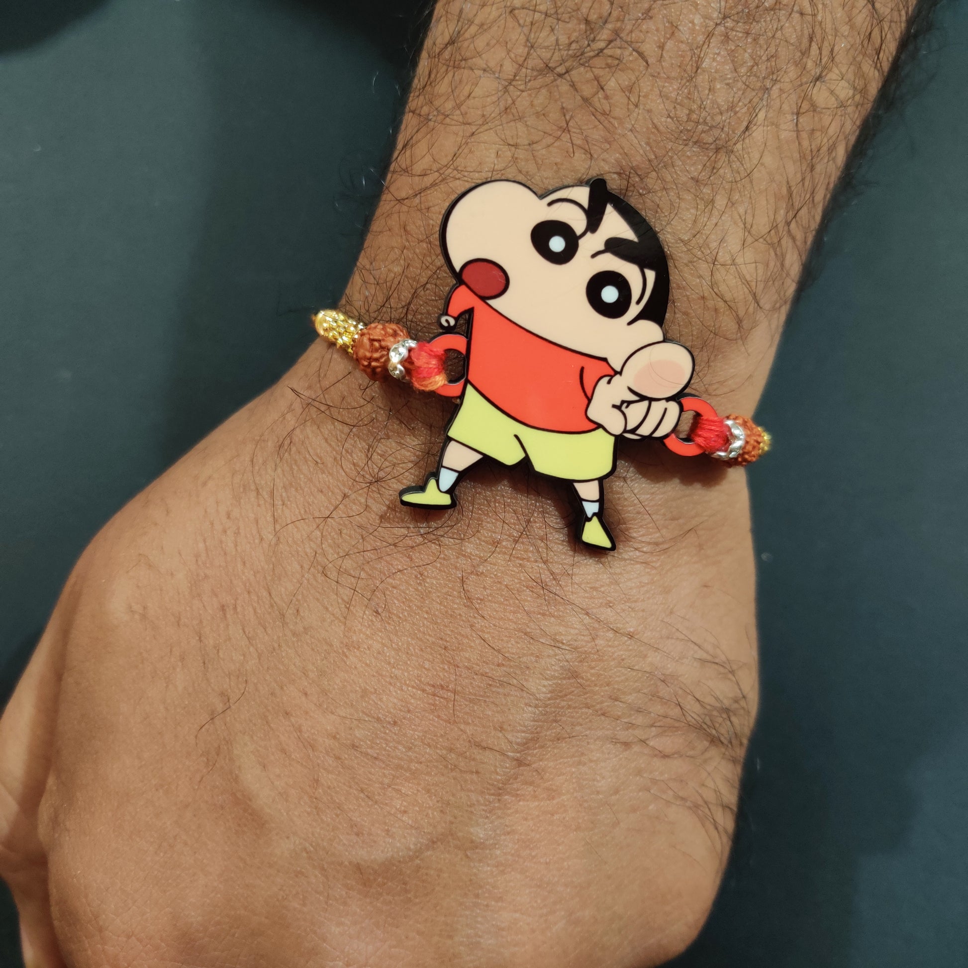 Hilarious Shinchan Wooden Rakhi with Rudraksha thread worn on a brother's wrist.